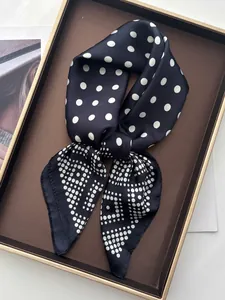 Close-up of elegant silk square scarf with polka dot patterns on a display tray