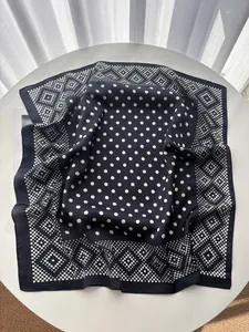 Close-up of polka dot and geometric pattern on silky navy blue square scarf