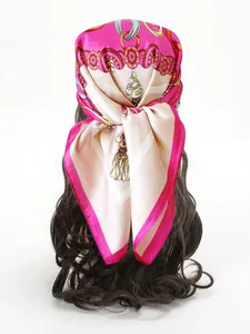 Dettaglio di un foulard di seta con stampa a catena indossato sui capelli con stile