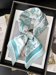 Close-up of silk scarf with green floral prints and striped edges in elegant knot style