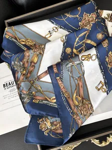 Close-up of vintage equestrian print silk scarf with gold chains on a luxury tray