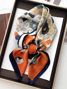 Dettaglio di un foulard in seta con stampe di gatti in arancione e blu da donna