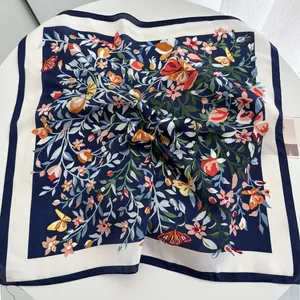 Vue détaillée du foulard en soie avec imprimé fleurs et papillons et bordure bleu marine
