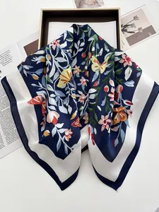 Détail d'un foulard en soie avec fleurs, papillons jaunes et motifs bleu marine