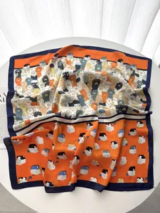 Dettaglio di un foulard in seta con motivi di gatti animati e impronte di zampe