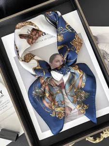 Detail of luxury silk scarf with equestrian patterns folded on a black wooden tray