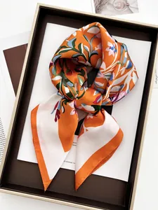 Détail d'un foulard en soie à imprimé floral et papillon en orange vif élégant