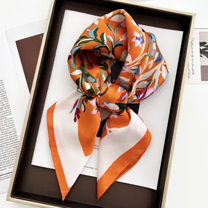 Foulard en satin orange à imprimé floral présenté dans une boîte cadeau élégante