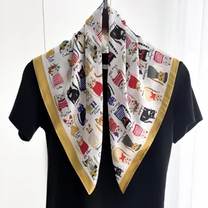 Dettaglio del foulard quadrato in seta con illustrazioni di gatti e bordi gialli vivaci