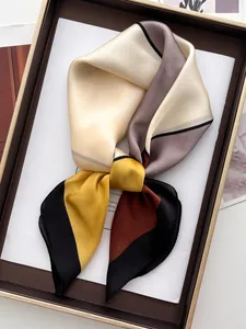 Détail d'un foulard carré en soie présentant des blocs de couleurs géométriques doux