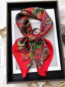 Detailansicht eines roten Seidenschals mit Paisleymuster und glänzender Satinstruktur