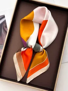 Détail d'un foulard en soie à motifs géométriques et texture satinée lisse