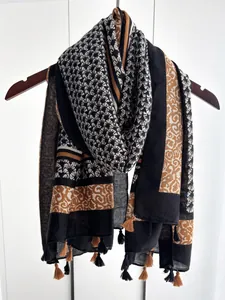 Detail of bohemian scarf featuring geometric fan patterns and tassel fringe trim