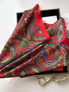 Makroaufnahme eines roten Paisley-Seidenschals mit satinartigem Glanz in edler Geschenkbox