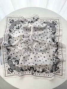 Detail of luxury silk square scarf with paisley pattern and star print on white fabric
