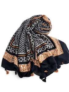 Detail of bohemian printed shawl with ethnic wave patterns and bicolored tassels