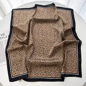Dettaglio di un foulard quadrato leopardato con bordi neri e consistenza in seta satin