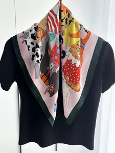 Dettaglio del foulard quadrato in finta seta con vivaci motivi di gatti su base rosa