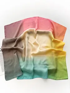 Gros plan d'un foulard carré en soie légère dégradé arc-en-ciel avec bords ourlés