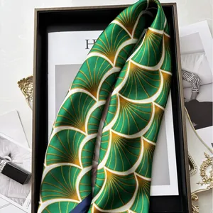 Elegante foulard in seta verde smeraldo con motivi a onde in un vassoio di lusso