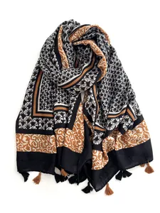 Detail of vintage patterned shawl with fringe tassels and geometric fan print in warm tones