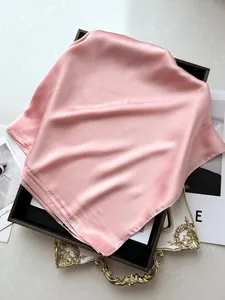 Vue détaillée du foulard en satin rose clair montrant texture lisse et fini brillant