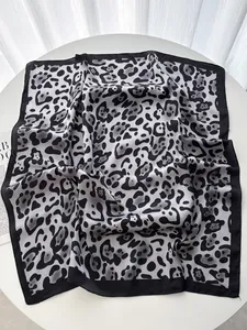 Dettaglio della trama del foulard in seta leopardata su una superficie bianca