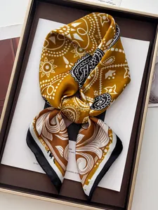 Dettaglio macro del foulard in seta con motivo paisley giallo zenzero e drappeggio elegante