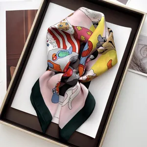 Dettaglio foulard in seta rosa con bordo verde e illustrazione di gatto in confezione regalo