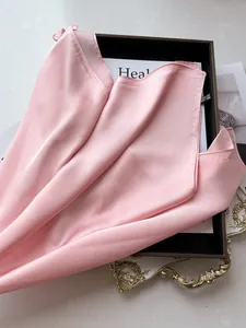 Vue détaillée d'un foulard carré en satin rose avec texture soie et bordure soignée