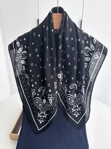 Close-up of black and white paisley cotton linen scarf with star and floral prints