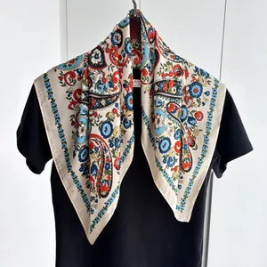 Détail d'un foulard en soie à imprimé paisley et fleurs sur un cintre en bois