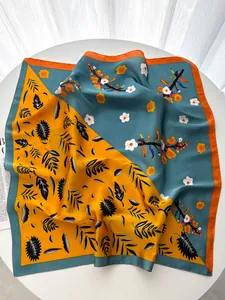 Detail of elegant square silk scarf with floral patterns on white round table background