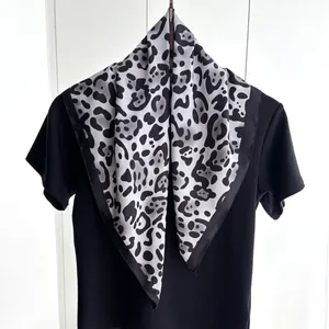 Elegante foulard in seta con stampa leopardata grigia drappeggiato su t-shirt nera