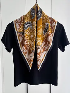 Dettaglio di foulard quadrato paisley con motivi floreali boho e trama satinata