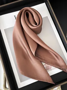 Détail d'un élégant foulard en satin mocha avec lustre soyeux et bords surpiqués