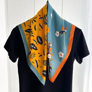 Detail of printed silk scarf showing split contrast colors and floral plant patterns