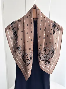 Detail showing the brown paisley and star pattern on light cotton linen square scarf