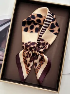 Detail shot of leopard print silk scarf with satin finish on a brown vintage tray