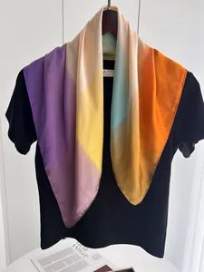 Gros plan d'un foulard carré en soie dégradée aux teintes violettes et orange