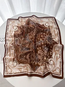 Foulard quadrato in seta paisley su tavolo bianco con rivista di moda decorativa