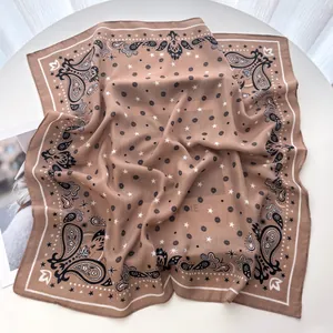 Macro detail of brown paisley silk scarf with star patterns and refined white hem edge