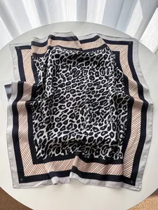 Vue détaillée d'un grand foulard en soie à imprimé léopard avec bordure rayée noir et blanc