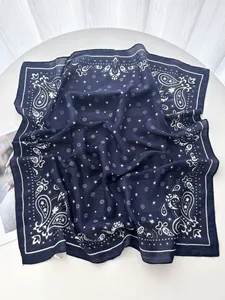 Detail of navy blue paisley and star pattern on a soft square neck scarf texture
