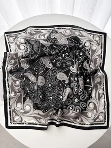 Dettaglio del motivo paisley e della trama setosa sul foulard bianco e nero