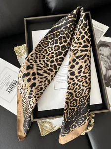 Detail shot of a leopard print silk scarf with satin finish and gold rolled edges