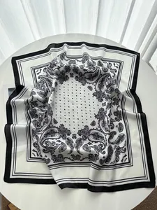 Detailaufnahme von schwarzem und weißem Paisley-Muster auf Seidenschal-Quadrat
