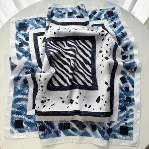Detailed close-up of navy blue and white silk scarf featuring zebra and geometric patterns