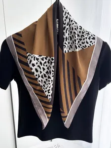 Detail of silk-satin square scarf featuring leopard print and geometric patchwork patterns