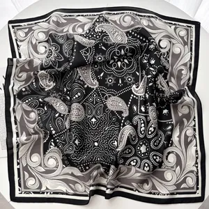 Dettaglio di un foulard di seta quadrato con eleganti motivi paisley bianchi e neri